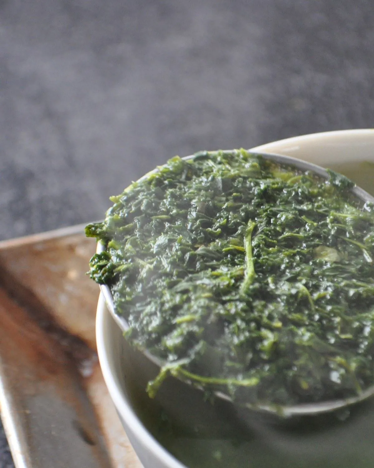 Brewed Asatsuyu tea leaves on a strainer, showing the fine particles characteristic of fukamushicha